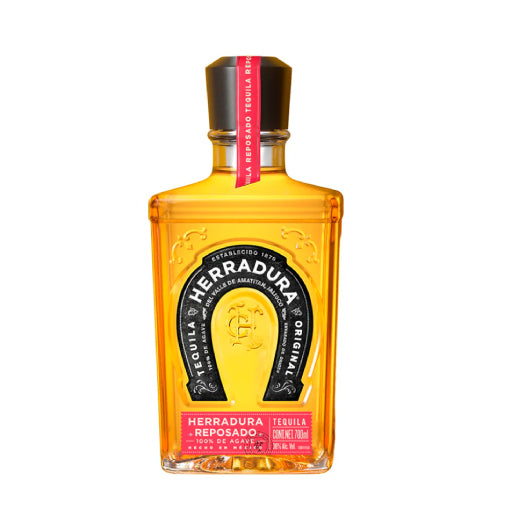 A beautiful, close-up shot of Herradura Reposado in a tasting glass, highlighting its rich amber color, or a cocktail like a Tequila Old Fashioned.